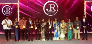 Group photo of the eleven Jeppiaar Icon Awards 2024 recipients on stage, holding their awards