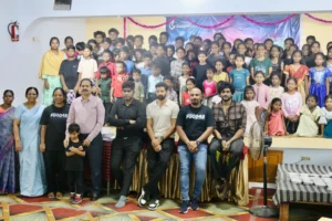 Food42 – 2025 campaign launch event showing actors Santhosh Prathap and Raanav, Goodness Foundation team members, and dozens of children from the community gathered together symbolizing the collective effort to combat hunger in India.
