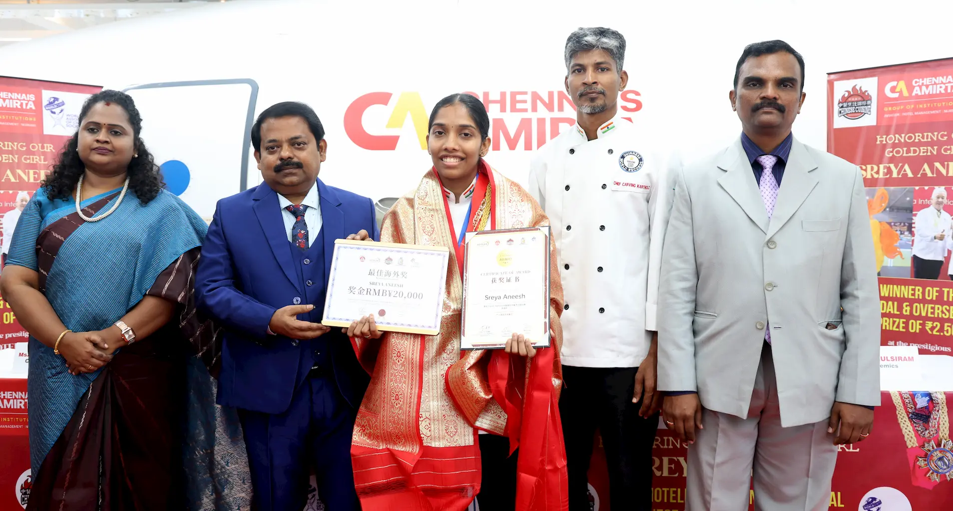 Ms. Sreya Aneesh of Chennais Amirta holding certificates after winning the Gold Medal at the 2025 Hotelex China International Culinary Championship, felicitated by Chairman Mr. R. Boominathan, Chef Karthik, and institute dignitaries.