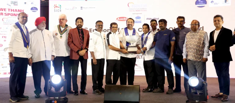 Group photo of chefs, dignitaries, and award winners holding the championship trophy at the 7th SICA Culinary Olympiad and Food Competition 2025 award ceremony in Chennai.
