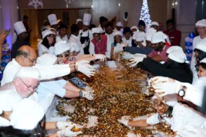 Guests and hotel staff joyfully mixing dried fruits together during the Grand Madurai Christmas Cake Mixing Ceremony.